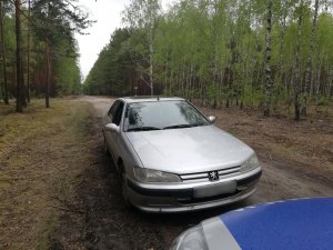 samochód i fragment radiowozu stojące w lesie
