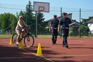 policjanci obserwują sposób jazdy dziecka na rowerze
