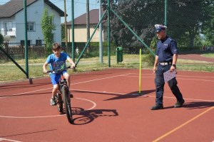 policjanci obserwują sposób jazdy dziecka na rowerze