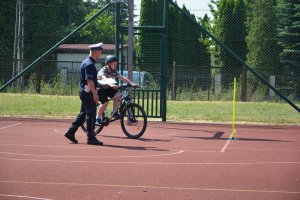 policjant obserwuje sposób jazdy dziecka na rowerze