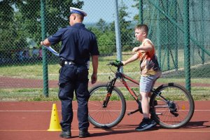 policjant obserwuje sposób jazdy dziecka na rowerze