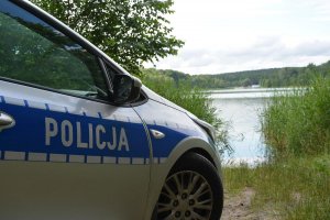 napis policja na radiowozie na tle jeziora