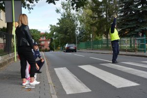 policjantka z dziećmi przy przejściu dla pieszych, policjant kieruje ruchem na drodze