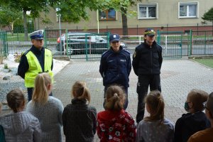 policjanci i strażnik miejski rozmawiają z dziećmi