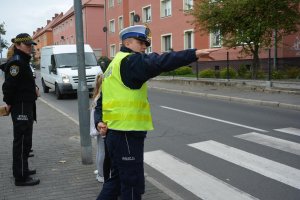 policjant, strażnik miejski i dzieci przy przejściu dla pieszych