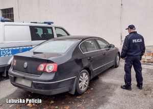 policjant stoi przy samochodzie