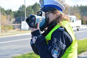 policjantka mierzy prędkość nadjeżdżającego pojazdu