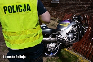 policjant i motocykl, który uderzył w ogrodzenie