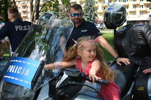 dziewczynka na motocyklu, obok policjant