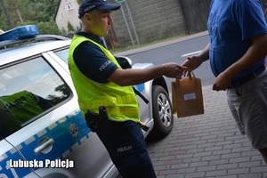 policjant wręcza torebkę z upominkami