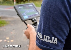 napis Policja na koszulce, w tle ekran z kamery drona