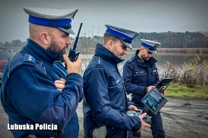 policjanci obserwują ekran do obsługi drona