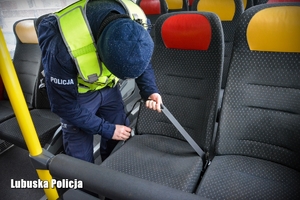 policjant kontroluje wyposażenie autobusu