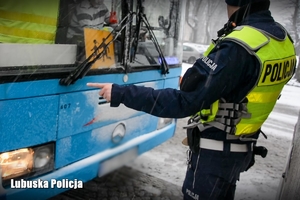 policjant kontroluje stan techniczny autobusu
