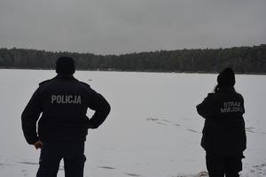 policjant i strażnik miejski kontrolują jezioro