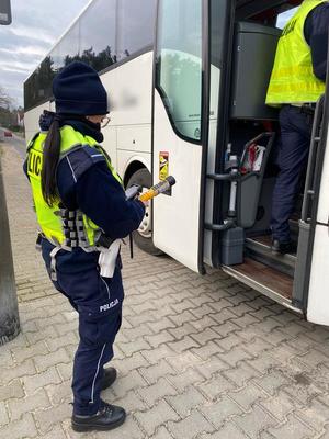 policjanci kontrolują autokar i jego kierowcę