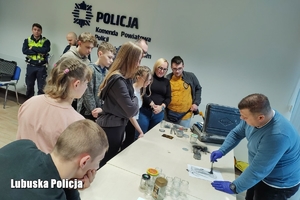 Policjanci wspólnie z technikiem kryminalistyki ujawniają odciski palców