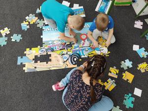 dzieci układają  wieloformatowe puzzle