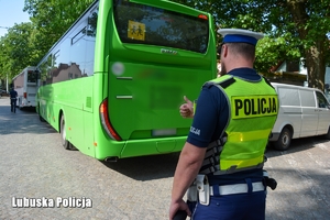 Funkcjonariusz sprawdza działanie tylnych świateł w autobusie.