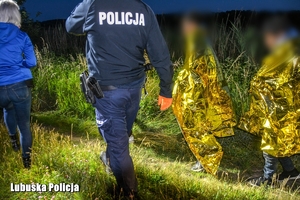 Policjanci i strażacy prowadzą mężczyzn.