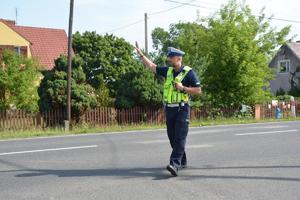 policjant ręką daje znak do zatrzymania się