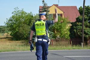 policjant ręką daje znak do zatrzymania się