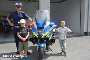 chłopcy z policjantem przy motocyklu