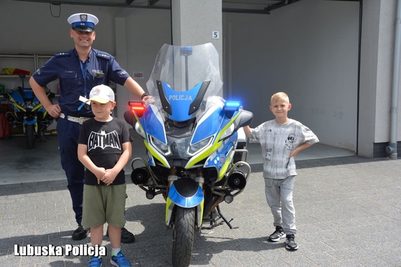 chłopcy z policjantem przy motocyklu
