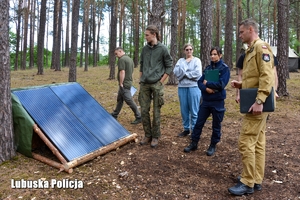 Przedstawiciele Policji, Straży Pożarnej i Nadleśnictwa Bytnica, w obecności osób odpowiedzialnych za organizację obozu kontrolują warunki przebywania harcerzy.