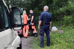 policjanci i ratownicy medyczni przy samochodzie