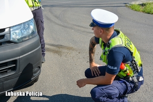 Policjant sprawdza oświetlenie w pojeździe