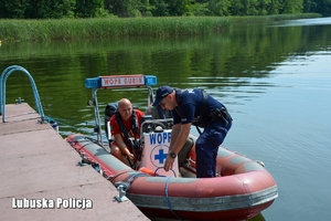 policjant, ratownik i strażnik leśny w łodzi motorowej