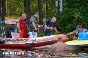 policjant, ratownik i strażnik leśny pływają łodzią motorową i kontrolują stan trzeźwości osób pływających na sprzętach wodnych