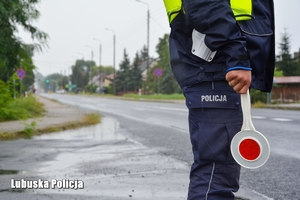 policjant trzyma tarczę do zatrzymywania pojazdów