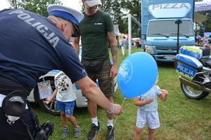 policjant wręcza dziecku balon