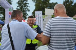 policjant rozmawia z uczestnikami dożynek