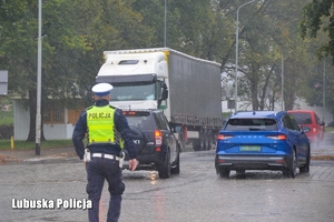 policjant na drodze po której jeżdżą samochody