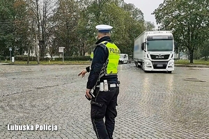 policjant na drodze, wskazuje kierującemu miejsce zatrzymania się