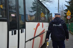 policjant idzie obok autobusu