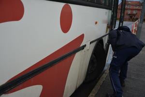 policjant sprawdza stan opon w autobusie