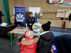 policjantka rozmawia z dziećmi przy stoisku profilaktycznym