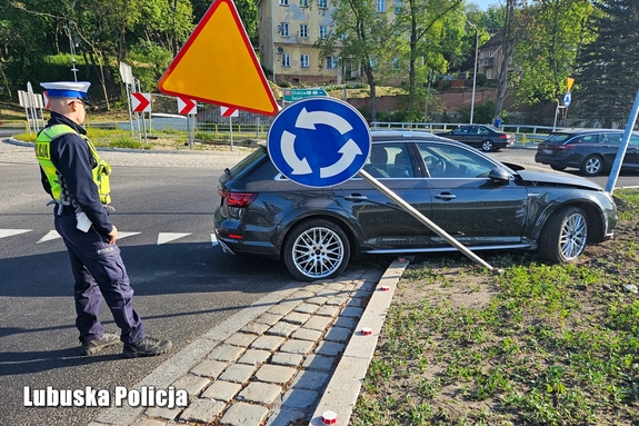 policjant stoi przy rozbitym pojeździe