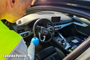 policjant w trakcie oględzin pojazdu zabezpiecza ślady