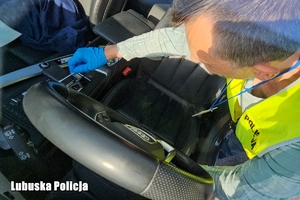 policjant w trakcie oględzin pojazdu zabezpiecza ślady