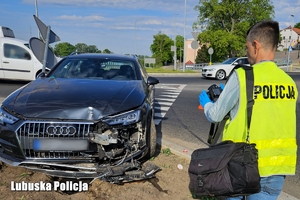 policjant w trakcie oględzin pojazdu robi zdjęcia