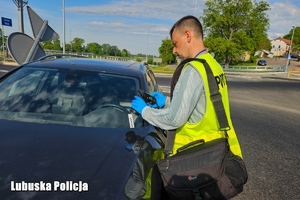 policjant w trakcie oględzin pojazdu robi zdjęcia