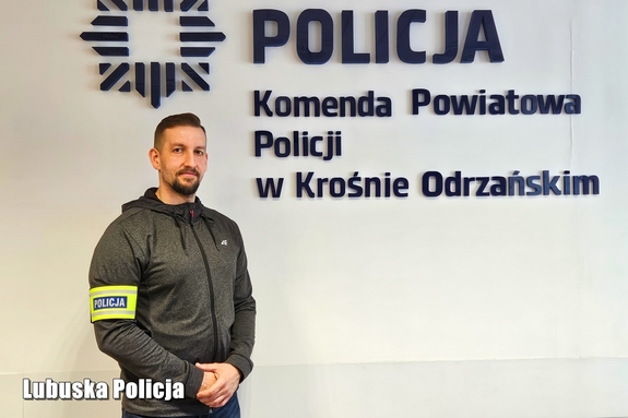 mężczyzna przy ścianie z napisem Policja, Komenda Powiatowa Policji w Krośnie Odrzańskim