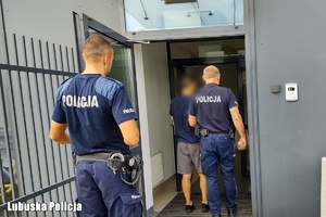 policjanci wchodzą z zatrzymanym do jednostki