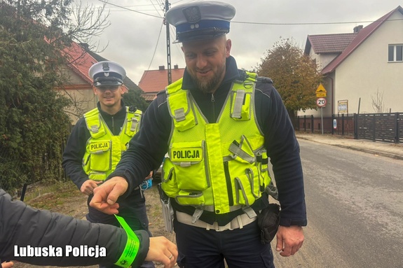policjanci rozdają opaski odblaskowe