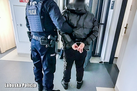 policjant prowadzi zatrzymanego